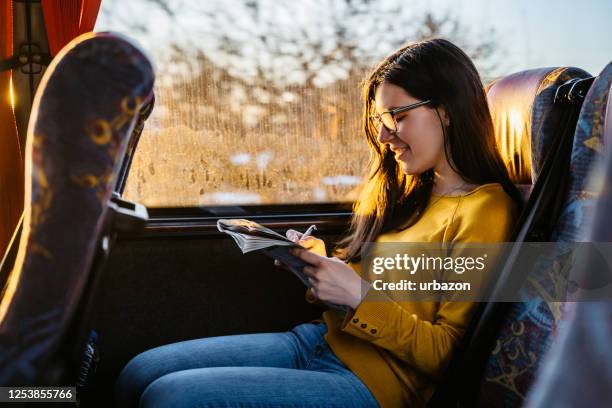 résoudre les mots croisés dans le bus - bus photos et images de collection