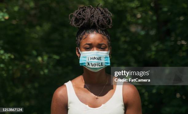 la femme porte le masque de visage avec le message de protestation - unfairness photos et images de collection