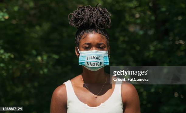 donna indossa maschera facciale con messaggio di protesta - manifestante foto e immagini stock