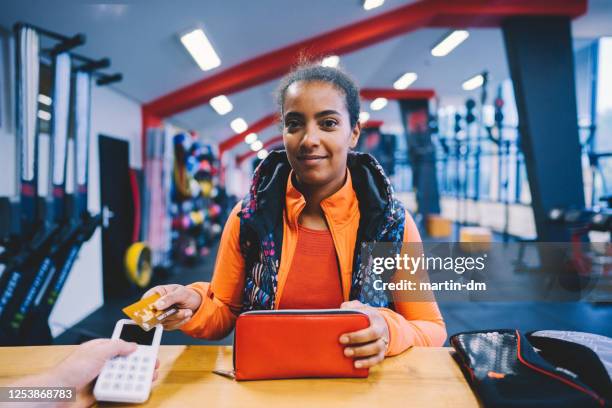 frau im fitnessstudio zahlen kontaktlos - charging sports stock-fotos und bilder