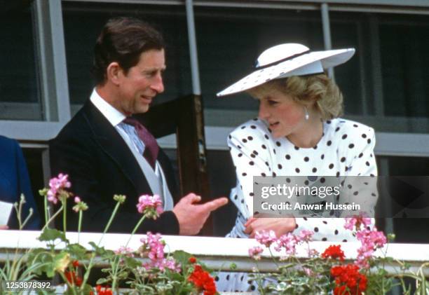 Diana Princess of Wales, wearing a dress by Victor Edelstein and hat by Frederick Fox, speaks to Charles Prince of Wales in the Royal box at the...