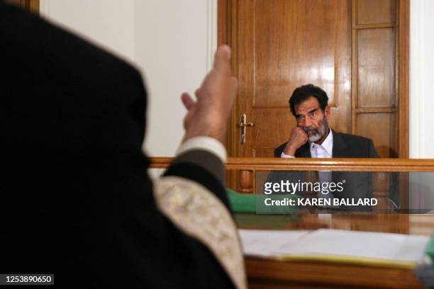Former Iraqi president Saddam Hussein listens to an Iraqi judge during his initial interview at an undisclosed location in Baghdad 01 July 2004, to...