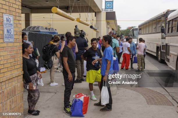 May 11: Migrants wait outside of a migrant processing center where buses drop off people to be processed on May 11, 2023 in Brownsville, Texas....