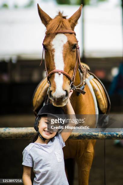 Cute girl and her beautiful horse looking at camera