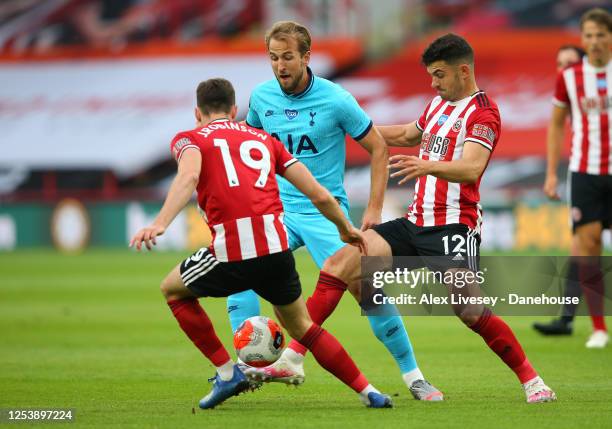 Harry Kane of Tottenham Hotspur is challenged by John Egan and Jack Robinson of Sheffield United during the Premier League match between Sheffield...