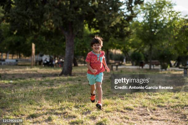 little four years old running boy in outdoors park - 4 5 years stockfoto's en -beelden