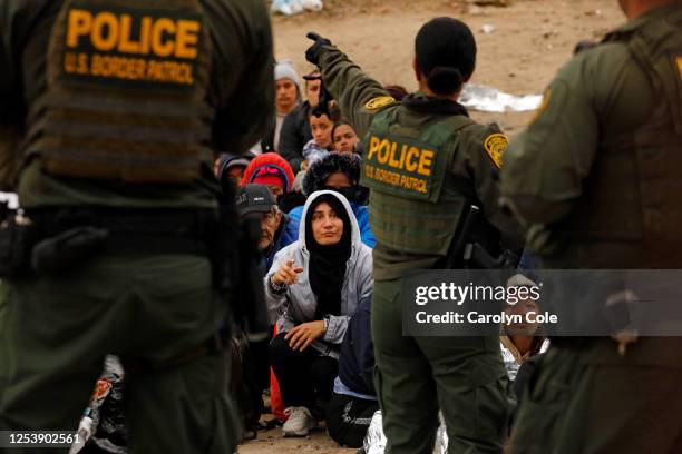 Border, United States-May 11, 2023-U.S. Border patrol agents make contact with migrants hoping to cross into the United States from Tijuana, Mexico...