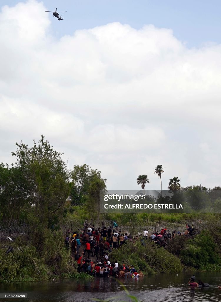 Migrants cross the Rio Grande River as they try to get to the US, as ...