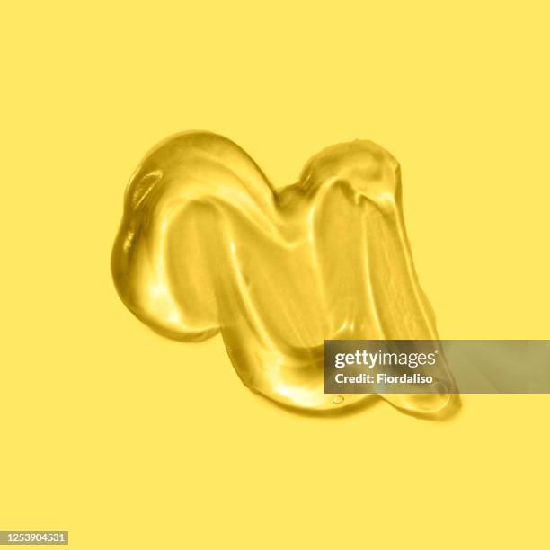 transparent liquid gel on a yellow background - hair gel stock pictures, royalty-free photos & images