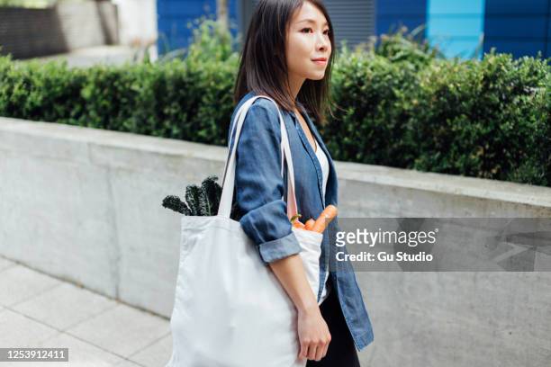 young woman shopping ethically, living a sustainable lifestyle - tote bag stock pictures, royalty-free photos & images