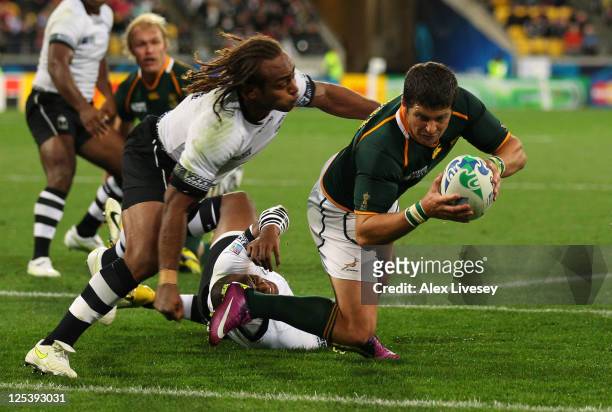 Morne Steyn of the Springboks dives past Gaby Lovobalavu of Fiji to score his team's fourth try during the IRB 2011 Rugby World Cup Pool D match...