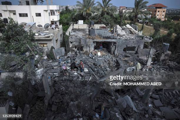 People sift through the rubble of a building hit in an Israeli air strike in Biet Hanoun, in the northern Gaza Strip, on May 12, 2023. Israel's...