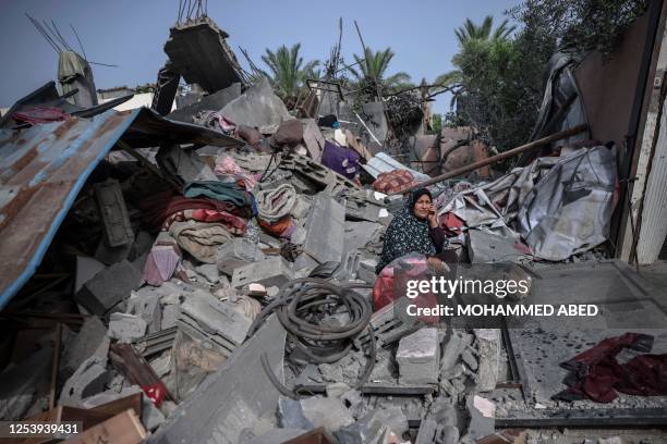 Woman sits amidst the rubble of a building hit in an Israeli air strike in Biet Hanoun, in the northern Gaza Strip, on May 12, 2023. Israel's...