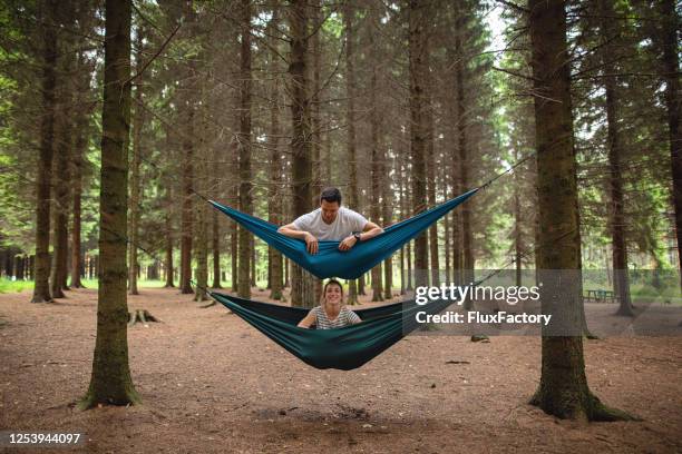 contented couple bonding out in the forest - hammock camping stock pictures, royalty-free photos & images