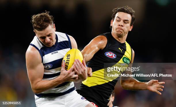 Mitch Duncan of the Cats and Daniel Rioli of the Tigers compete for the ball during the 2023 AFL Round 09 match between the Richmond Tigers and the...