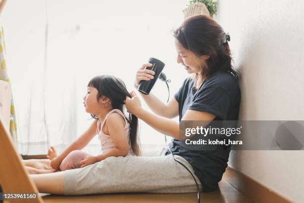 mother drying her daughter's hair with dryer - blow drying hair stock pictures, royalty-free photos & images