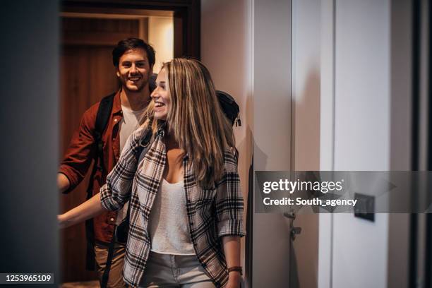 un par de viajeros acaban de llegar a la habitación del hotel - motel pareja fotografías e imágenes de stock