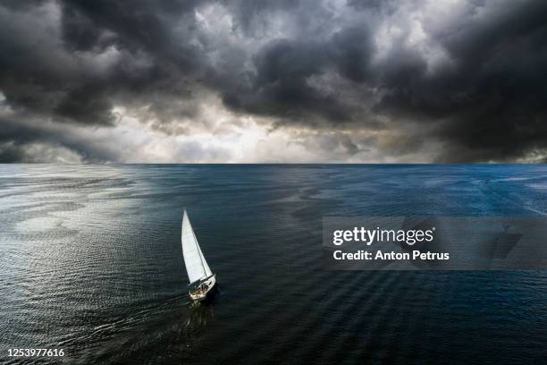 aerial view of a yacht in a storm with a dramatic sky - yacht top view stock-fotos und bilder