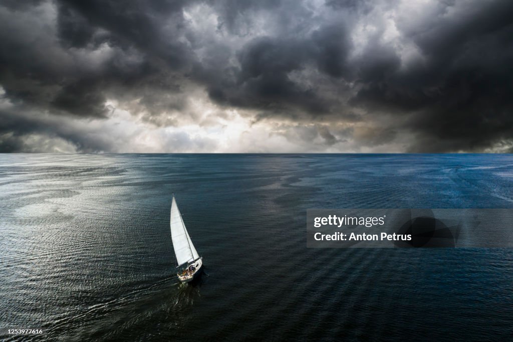 Aerial view of a yacht in a storm with a dramatic sky