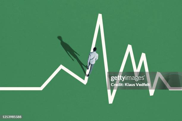 young man walking on white graph - medical concept photos et images de collection