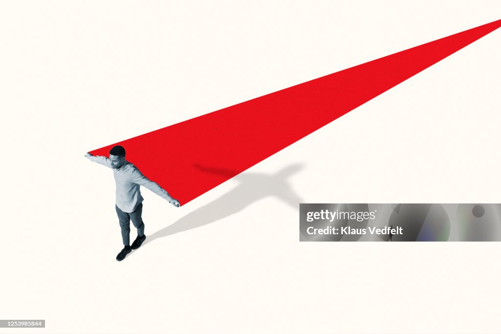 Man walking with arms outstretched by red ramp