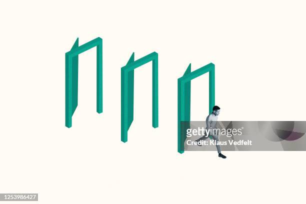 confident young man walking through green doorways - initiative stock pictures, royalty-free photos & images