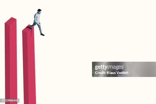 young man taking the plunge from tall bar graph - leading edge stock pictures, royalty-free photos & images