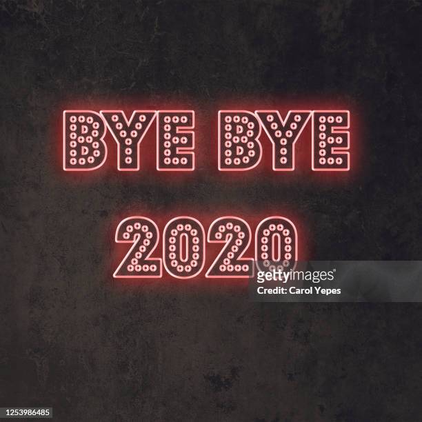 bye bye 2020 text in neon lights in black background - 2020 foto e immagini stock