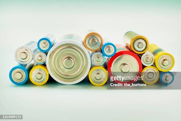 still life of stack of colorful old batteries - alkaline stockfoto's en -beelden