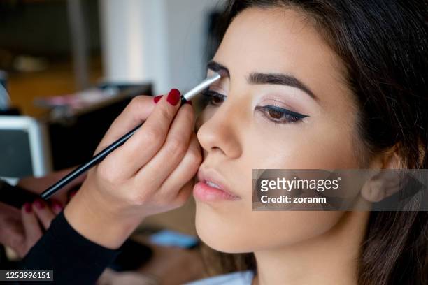 make-up artist applying eyebrow shadow with brush - concealer stock pictures, royalty-free photos & images
