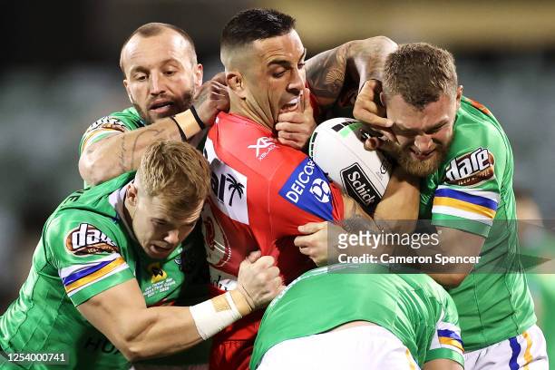 Paul Vaughan of the Dragons is tackled by the Raiders defenders during the round eight NRL match between the Canberra Raiders and the St George...