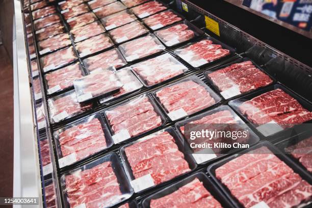 different types of packed meat in the meat cooler - koelkast stockfoto's en -beelden