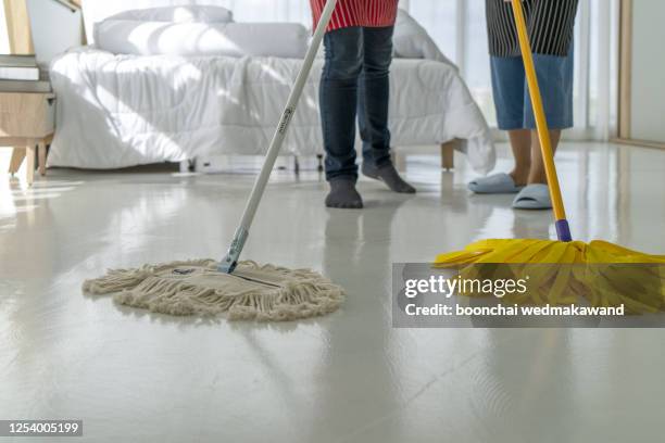 unrecognizable couple mopping floor together, doing spring-cleaning at home, cropped image with free space - aljofifa fotografías e imágenes de stock