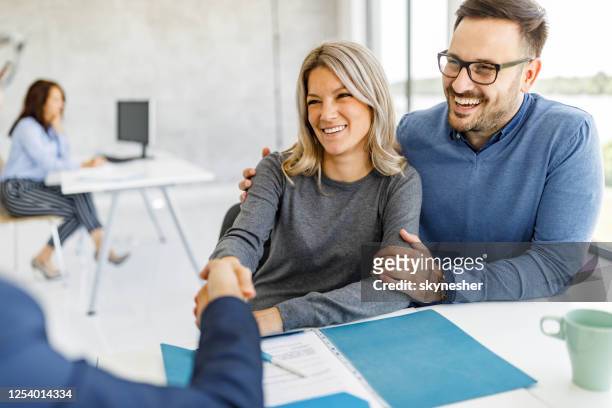 happy couple came to an agreement with their financial advisor in the office. - insurance stock pictures, royalty-free photos & images