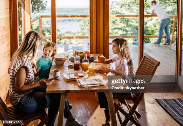 niños pequeños hablando con su madre durante el desayuno en la mesa del comedor. - chalet fotografías e imágenes de stock