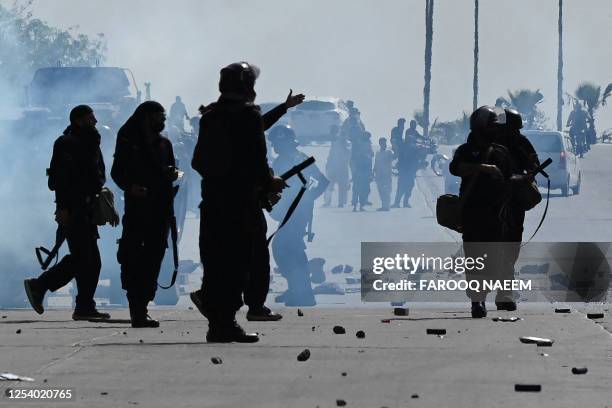 Policemen stand along a road to prevent Pakistan Tehreek-e-Insaf party activists and supporters of former Pakistan's Prime Minister Imran Khan from...