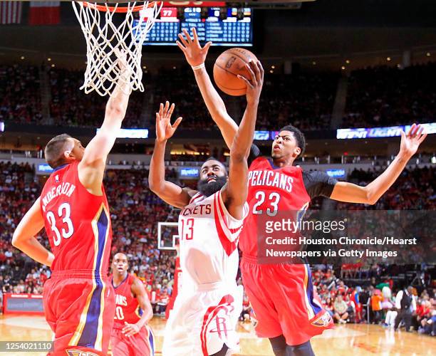 Houston Rockets guard James Harden center, heads to the baskets between New Orleans Pelicans forward Ryan Anderson left, and Pelicans forward Anthony...