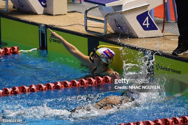 Cambodia's Kaing Muynin celebrates winning the women's 400m bi fins swimming final during the 32nd Southeast Asian Games in Phnom Penh on May 12,...