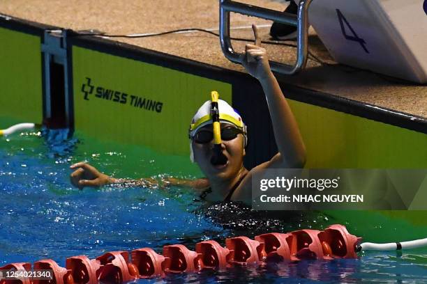 Cambodia's Kaing Muynin celebrates winning the women's 400m bi fins swimming final during the 32nd Southeast Asian Games in Phnom Penh on May 12,...