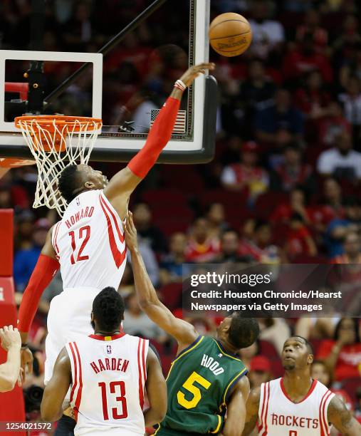 Houston Rockets center Dwight Howard left, blocks a shot by Utah Jazz guard Rodney Hood center, during the first quarter of NBA game action at the...