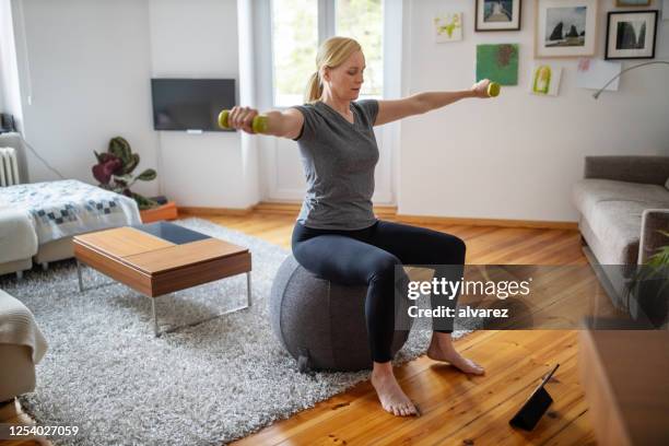 donna che fa allenamento online a casa - home workout foto e immagini stock