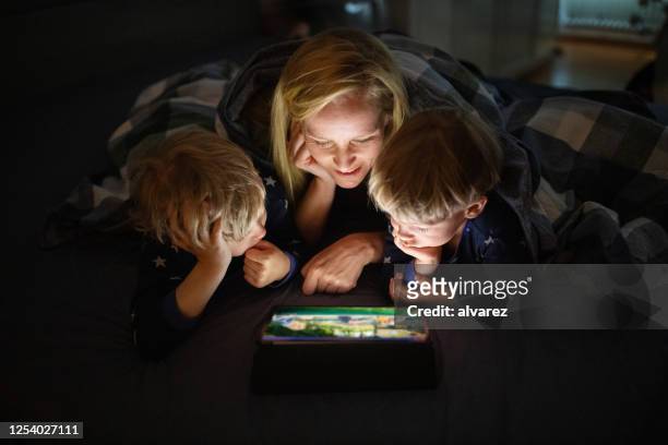 familie genießt es, film auf digitalem tablet zu sehen - mutter tablet zuhause stock-fotos und bilder