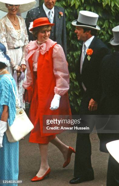 Diana, Princess of Wales, wearing a red outfit designed by Bellville Sassoon, a red hat with a white flower designed by John Boyd, red heels and...