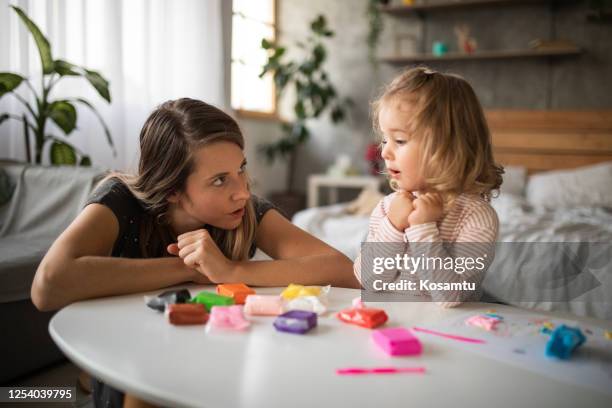 nieuwsgierig leuk peutermeisje dat haar moeder vraagt om zich met haar aan te sluiten om met het kleispel van het kleurrijke kind te spelen - peuter stockfoto's en -beelden