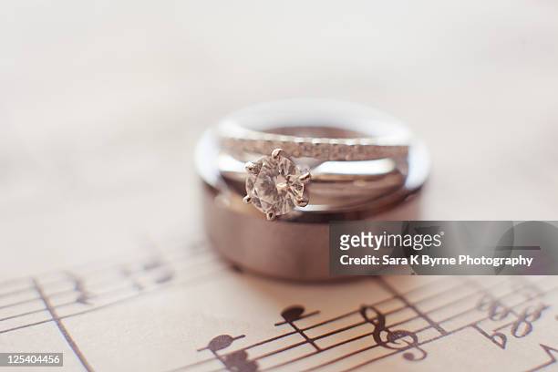 wedding rings on music sheet - tungsten metal foto e immagini stock