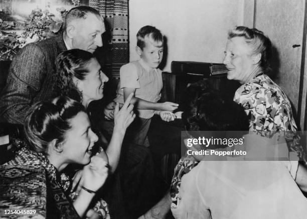 Arnoldus Koen, his grandson Jan Blankers-Koen, and wife Helena Koen listen to the radio, on which rests the family bible, as Fanny Blankers-Koen wins...