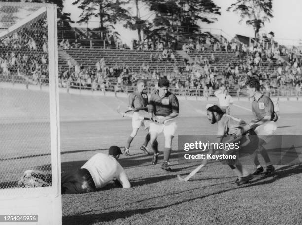 The Great Britain goalkeeper protects his goal from Indian hockey player Balbir Singh Sr in the semifinal of the men's field hockey tournament at...