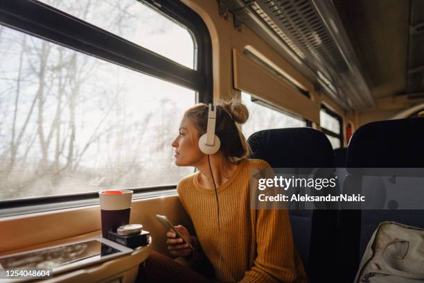 young woman riding a train - passageiro imagens e fotografias de stock