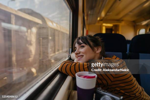 donna sorridente su un treno - vagone foto e immagini stock