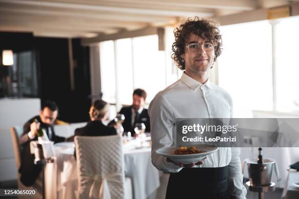 professional waiter in a luxury restaurant serving food - empregado de mesa imagens e fotografias de stock